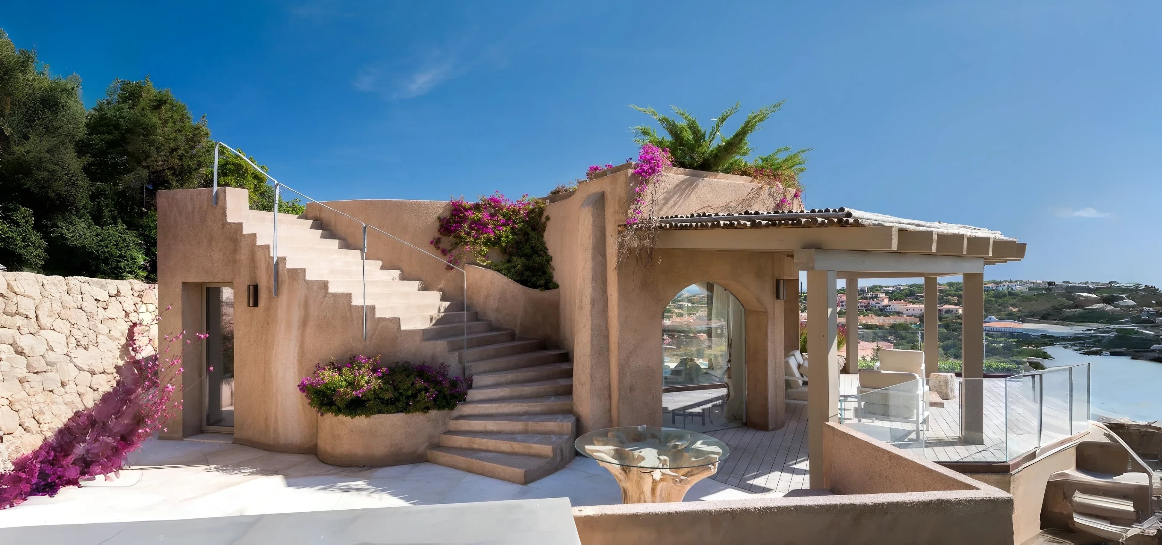 Villa in stile mediterraneo con scala esterna in pietra e bouganville in fiore, affacciata sulla Costa Smeralda, nel nord della Sardegna